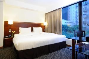 a bedroom with a large bed and a large window at Brighton Hotel Hong Kong in Hong Kong