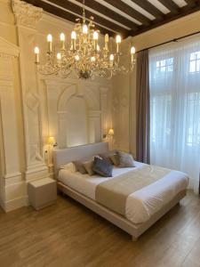 Un dormitorio con una cama grande y una lámpara de araña. en Château Pellisson, en Cognac