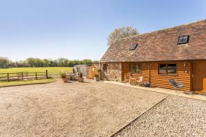 a cabin with a gravel driveway in front of it at Bridge Farm Holiday Cottages in Cow Honeybourne