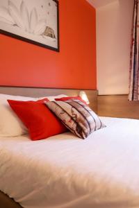 een bed met rode en witte kussens erop bij ACE Hôtel Travel Athée sur Cher - A85 Aire du Val de Cher in Athée-sur-Cher