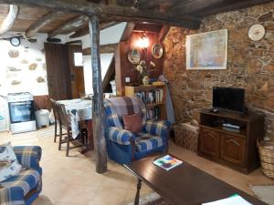 a living room with two chairs and a television at Casa Rustica in Arganil