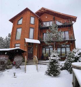 a large brick house in the snow with a christmas tree at Luxury Villa with pool and sauna in Chernivtsi