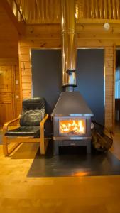 a wood stove in a room with a chair at Havurinne in Loppi
