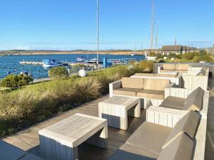 a row of benches sitting on a deck near the water at mönchgut living & spa in Gager