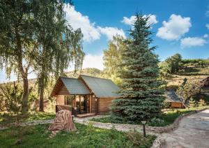 une cabane en rondins avec un pin en face de celle-ci dans l'établissement Oi-Qaragai Mountain Resort, à Besqaynar 214 autres photos