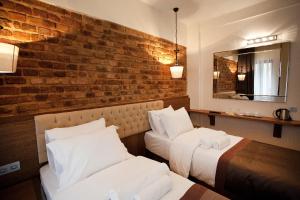 a hotel room with two beds and a brick wall at Pera Line Hotel in Istanbul