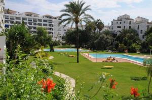 a view of a park with a swimming pool and buildings at Puerto Banus in Marbella