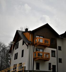 a large white building with wooden balconies on it at Apartament Ryś in Szklarska Poręba