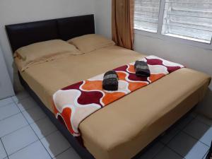 ein Bett mit Schuhen darüber in der Unterkunft Kost Carmelia Syariah Baranangsiang Bogor in Bogor