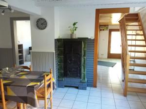a dining room with a table and a clock on a wall at Le petit St Blaise in Sainte-Marie-aux-Mines