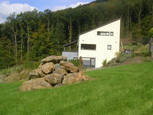 une maison blanche sur une colline avec un tas de rochers dans l'établissement Villa du Lac de Coo, à Stavelot