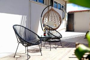 two chairs and a table on a patio at Havana 3 Luxury Pool and Sea Apartment in Gázion
