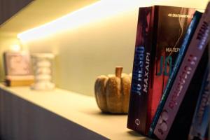 a shelf with books and a vase on it at Havana 3 Luxury Pool and Sea Apartment in Gázion