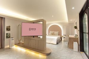 Cette chambre comprend un lit et un écran de projection. dans l'établissement 里萊行旅 - 桃園館, à Taoyuan