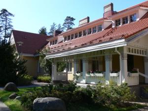 an old house with flowers in the front yard at Hotelli Tiiliriihi in Espoo