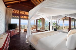 乌鲁瓦图Hidden Hills Villas - Small Luxury Hotels of The World的一间带床的卧室和一个可欣赏海景的阳台
