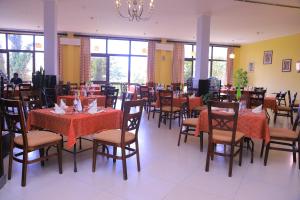 une salle à manger avec des tables et des chaises ainsi qu'un lustre dans l'établissement Haile Resort Hawassa, à Awasa