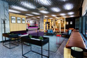 a lobby with couches and tables in a building at AZIMUT Hotel Siberia in Novosibirsk