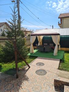 a gazebo with a christmas tree in a yard at Vila Adina in Eforie Nord