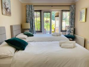 three beds in a room with a window at The Garden Suite in Basingstoke