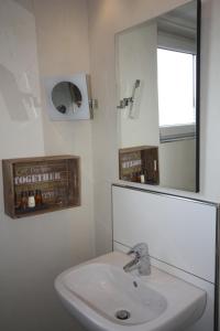 a bathroom with a white sink and a mirror at Hotel Haus Berger in Cologne