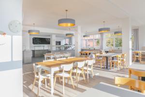 a kitchen and dining room with a table and chairs at Hotel Bethanien in Langeoog