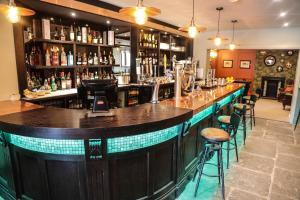 a bar with a wooden counter and stools at The Crown Hotel in Glastonbury
