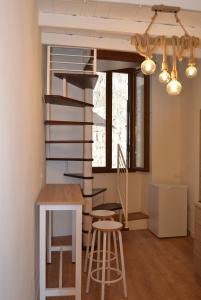 uma escada em espiral num quarto com um banco e uma mesa em Casa Alma em Bari