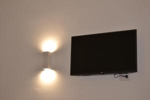 uma televisão de ecrã plano pendurada numa parede com luzes em Casa Alma em Bari