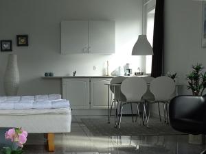 a kitchen with white cabinets and a table and chairs at Bogense Feriebo in Bogense