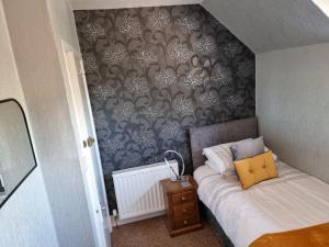 a small bedroom with a bed and a wall at Drumdale Bed and Breakfast in Inverness