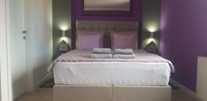 a purple bedroom with a large bed with two pillows at Apartment Mavero-Free Private Parking in Zagreb