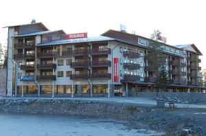 a large building with balconies next to a body of water at Ruka Ski Käenpesä in Ruka
