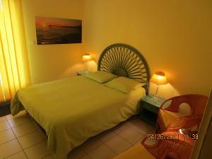 um quarto com uma cama grande e uma cadeira em Locatlantique em Aytré