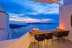 a balcony with a bar with a view of the ocean at Aroma Suites in Fira