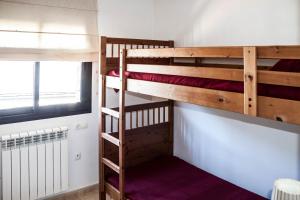 two bunk beds in a room with a window at DUPLEX FRENTE A PISTAS in El Tarter