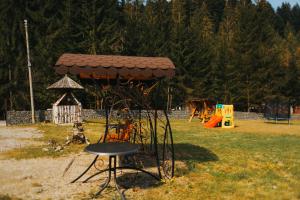 un parque con una silla y un parque infantil en Pensiunea Agnes en Durau