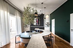 jadalnia z białym stołem i zieloną ścianą w obiekcie BEDWAVE Seaside Mansion w Pireusie