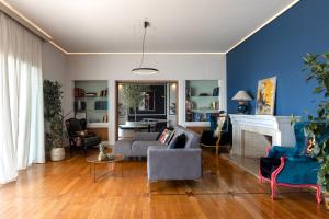 salon z niebieskimi ścianami, kanapą i kominkiem w obiekcie BEDWAVE Seaside Mansion w Pireusie