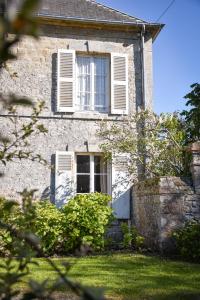 een oud stenen huis met een raam en een tuin bij Utah Beach Chambre hote in Sainte-Marie-du-Mont