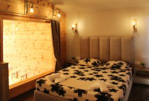 sypialnia z dużym łóżkiem i drewnianą ścianą w obiekcie Vista Cottage w Ulcinju