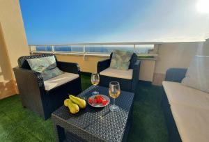 um quarto com duas cadeiras e uma mesa com copos de vinho em Los Gigantes Ocean View Apartment em Puerto de Santiago