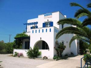 a white building with a palm tree in front of it at Mavromatis Studios in Naxos Chora