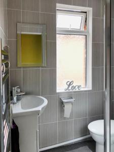 baño con lavabo y ventana con signo de amor en Sidings Holt - whole house sleeps up to 7 en Crewe