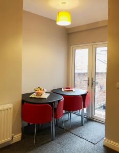 a dining room with two tables and red chairs at Sidings Holt - whole house sleeps up to 7 in Crewe