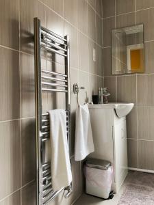 y baño con lavabo y ducha con toallas. en Sidings Holt - whole house sleeps up to 7 en Crewe