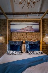 1 dormitorio con pared de ladrillo y cama con almohadas en 1 Queen Vic en Darling