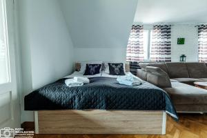 ein Schlafzimmer mit einem Bett und einer Couch in der Unterkunft Apartament 27 z tarasem in Jelenia Góra