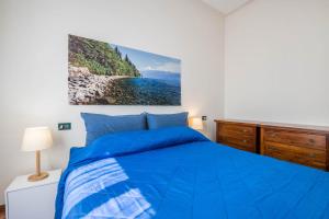 Villa Tosca في Pulciano: غرفة نوم بسرير ازرق ولوحة على الحائط +21 صورة