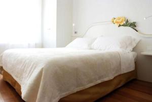 ein weißes Bett mit einer Blume darüber in der Unterkunft Locanda Mezzosale in Conegliano